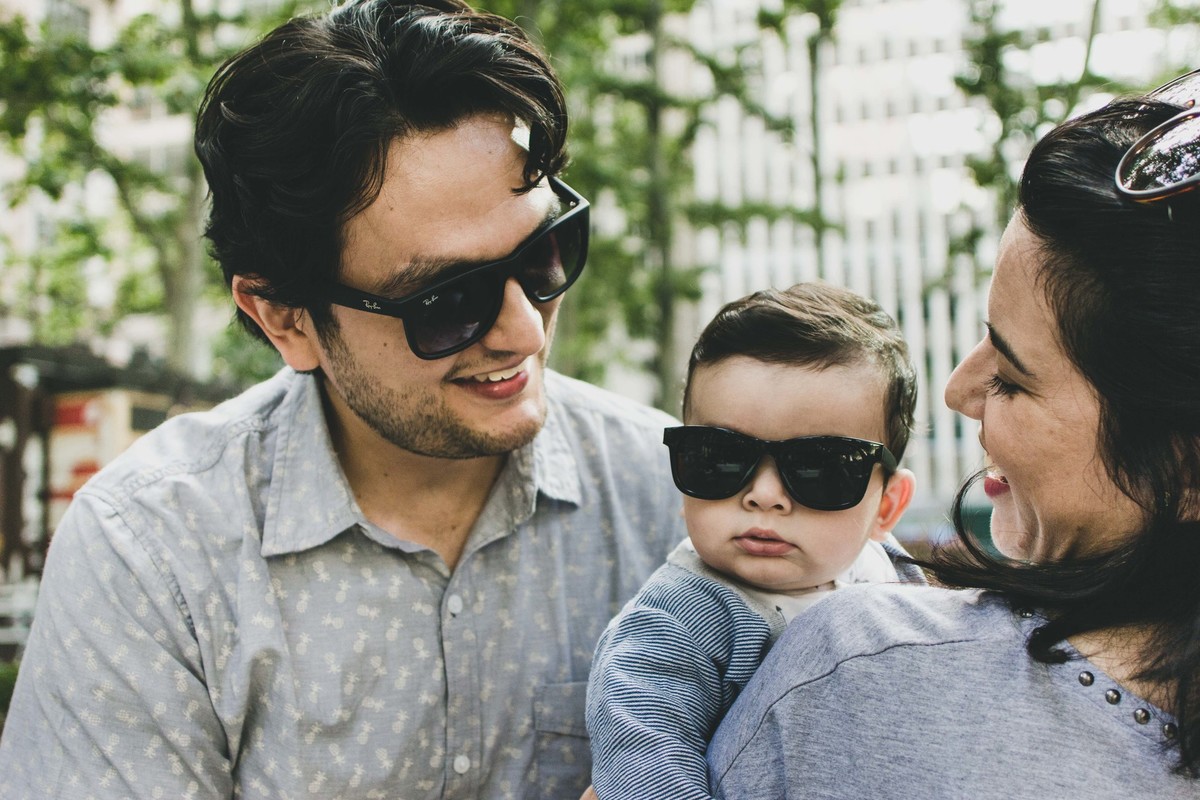 Ensaio fotográfico de família em Nova York, pai e filho com óculos escuro mãe sorrindo