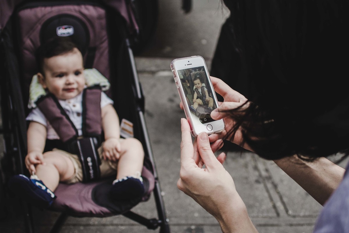 Ensaio fotográfico de família em Nova York, mãe tira foto de criança com celular, criança posa para a foto