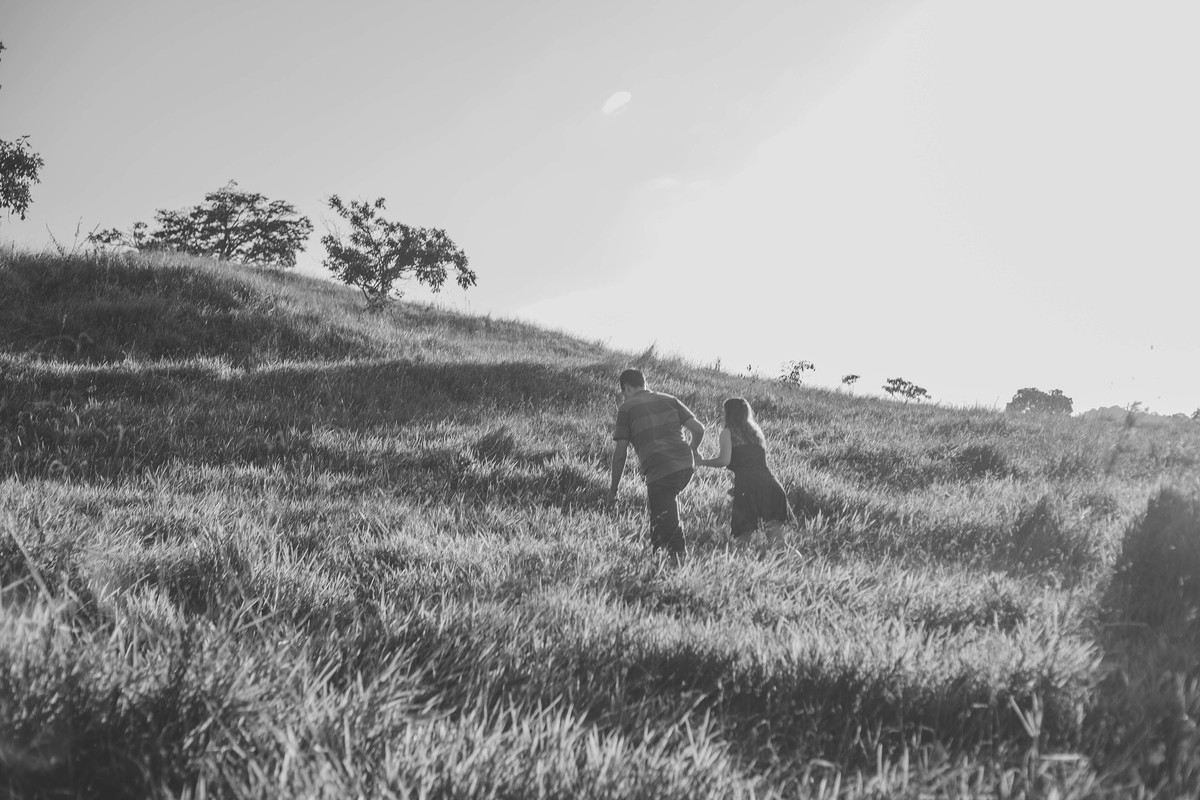 Fotografia de casal em preto e branco de casal andando de mão dadas na montanha em Betim Minas Gerais