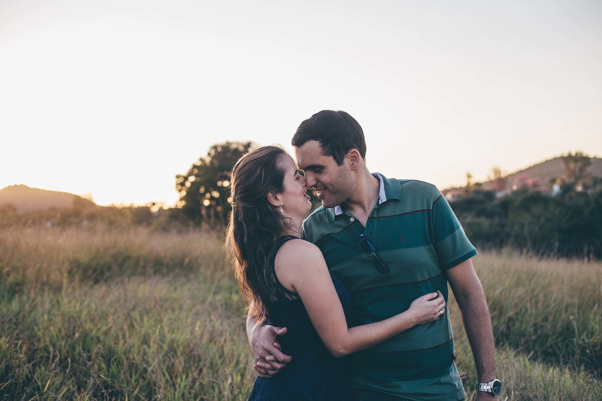 casal abraçado no por do sol e quase se beijando