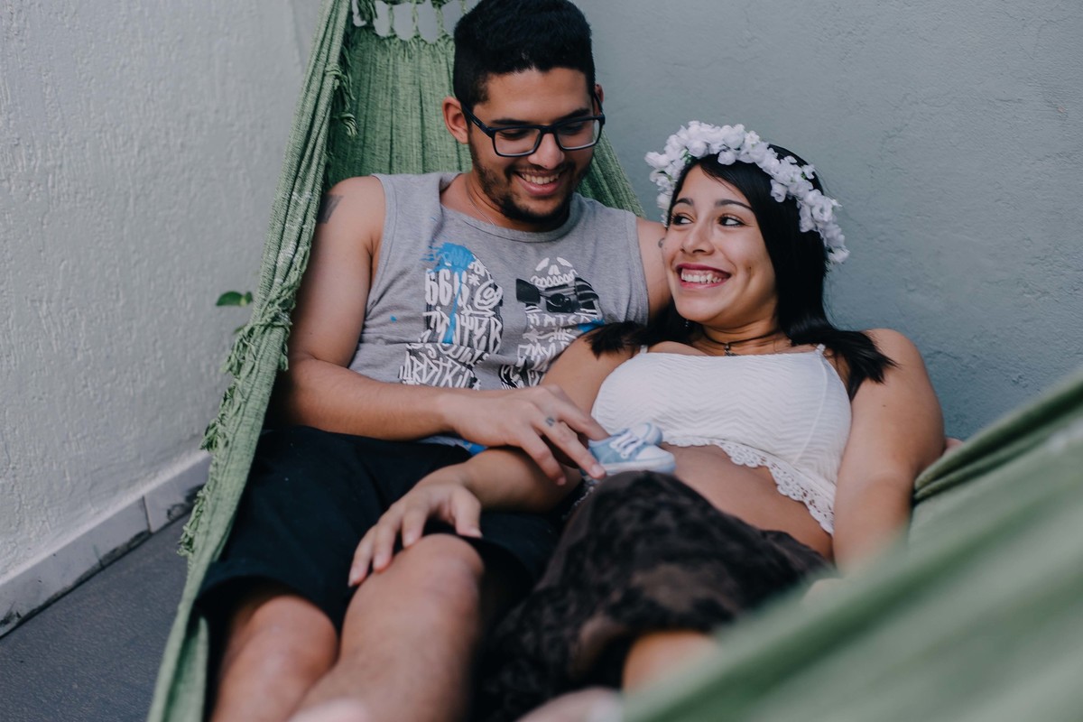 Recém casados deitados na rede e sorrindo