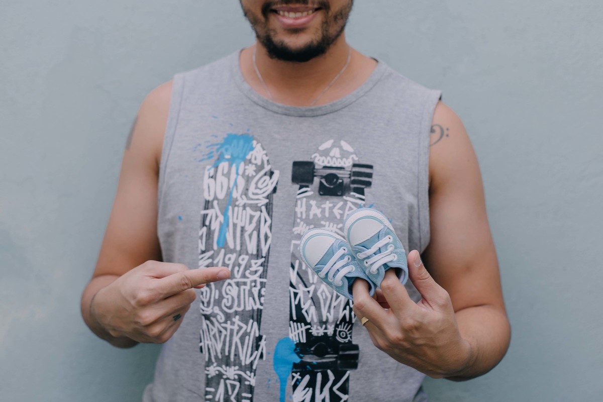 pai segurando sapatinhos de recém nascido