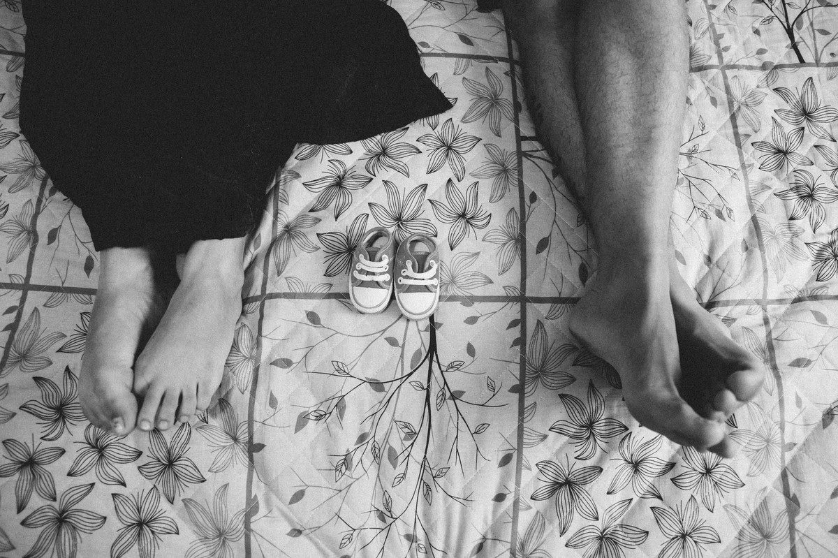 fotografia de pés e um sapatinho de recem nascido