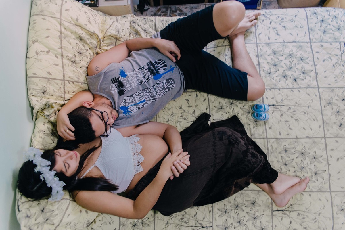 casal deitado na cama e fazendo carinho um no outro