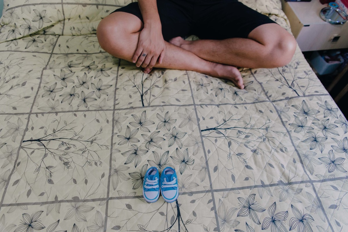 sapatinhos de recem nascido sobre a cama