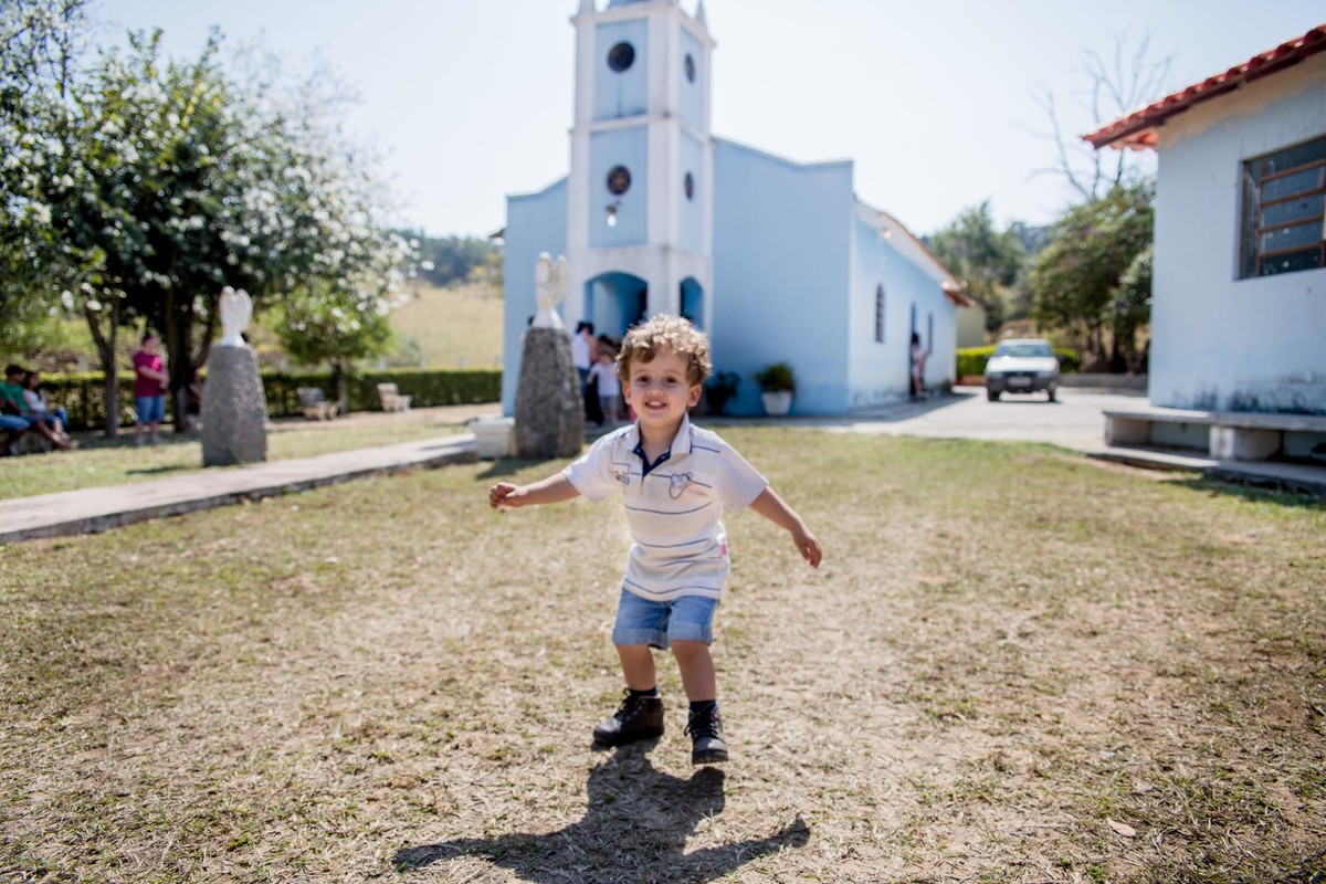 Criança sorrindo e se divertindo na frente da Igreja