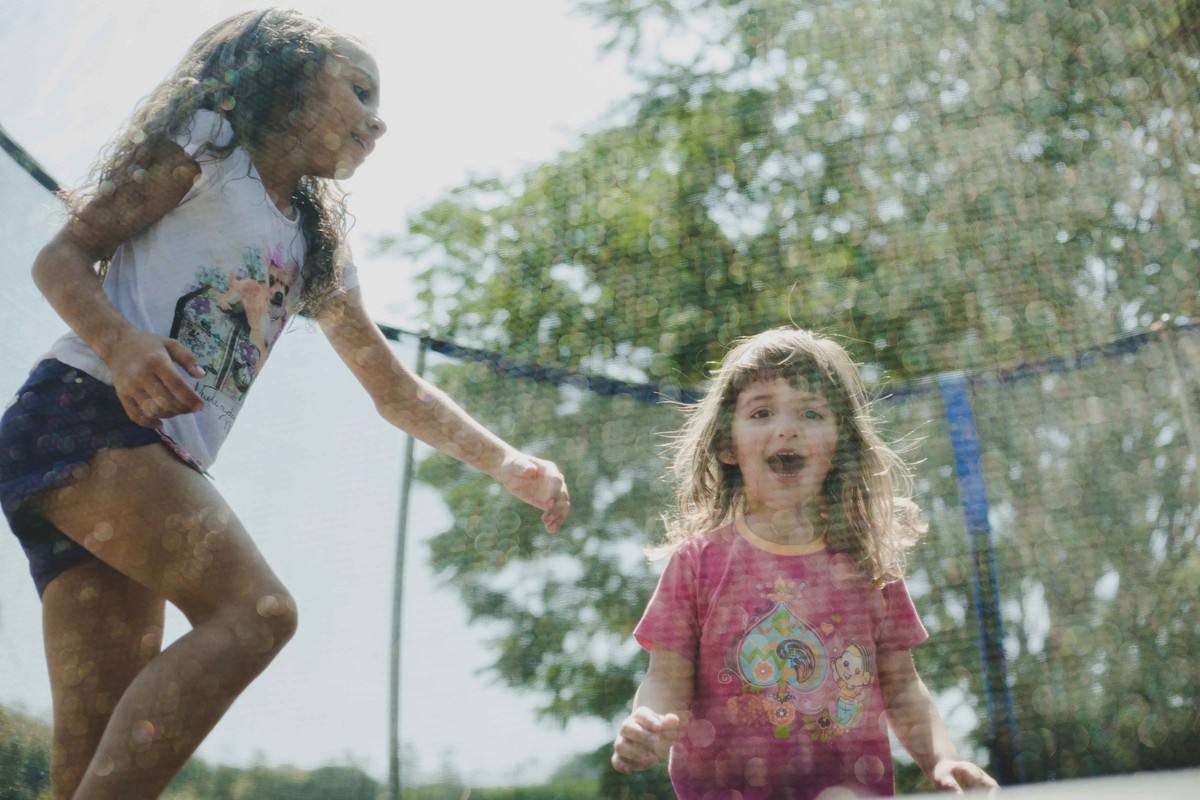 crianças sorrindo e pulando na cama elastica