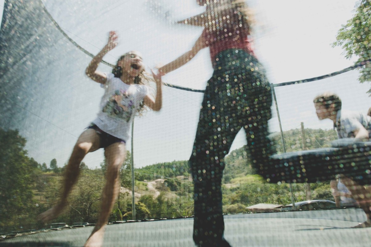 crianças pulando na cama elastica e se divertindo