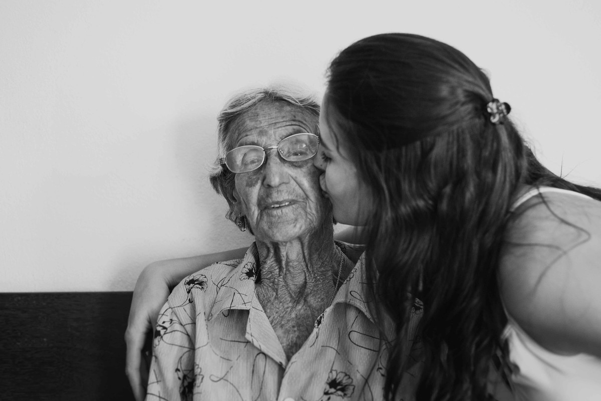 fotografia de familia da neta beijando o rosto da avó