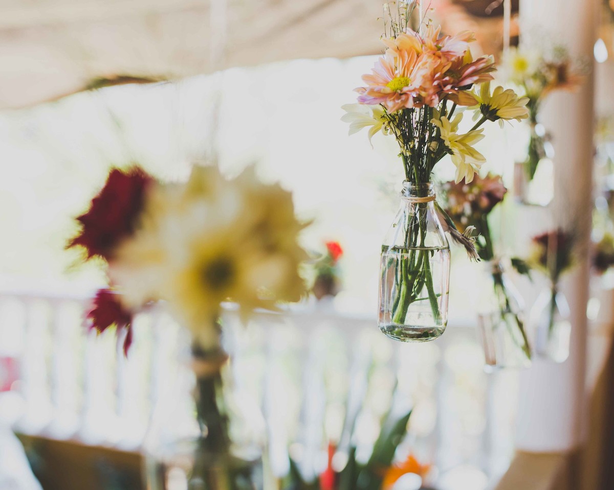 enfeite com garrafa de vidro e flores