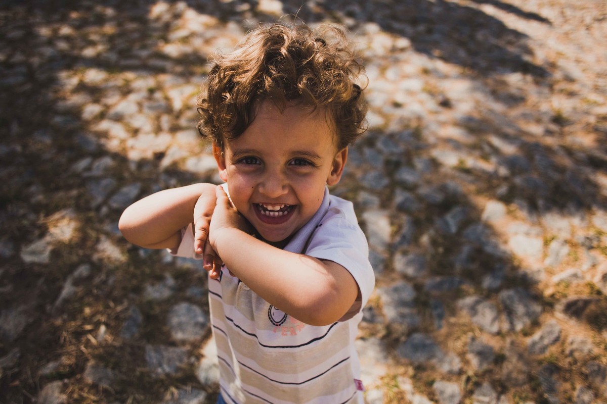 criança sorrindo enquanto brinca na grama