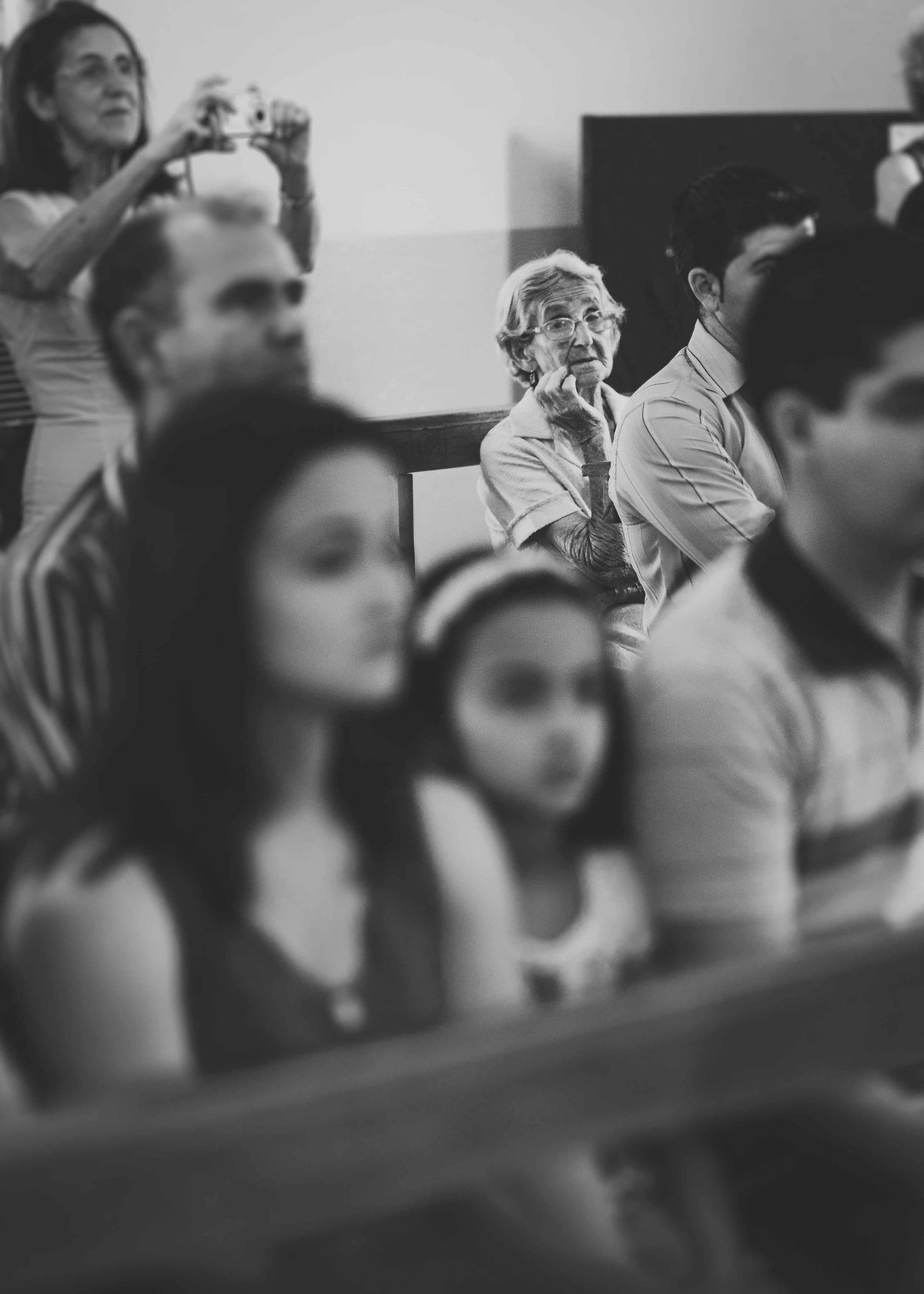 Dona Marieta sentada na e observando a missa