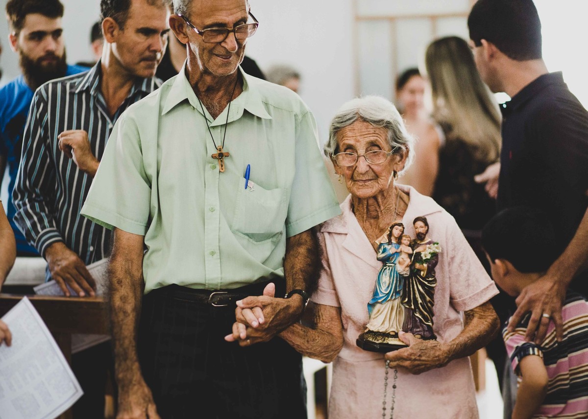 Dona Marieta entrando na igreja segurando a imagem de Nossa senhora