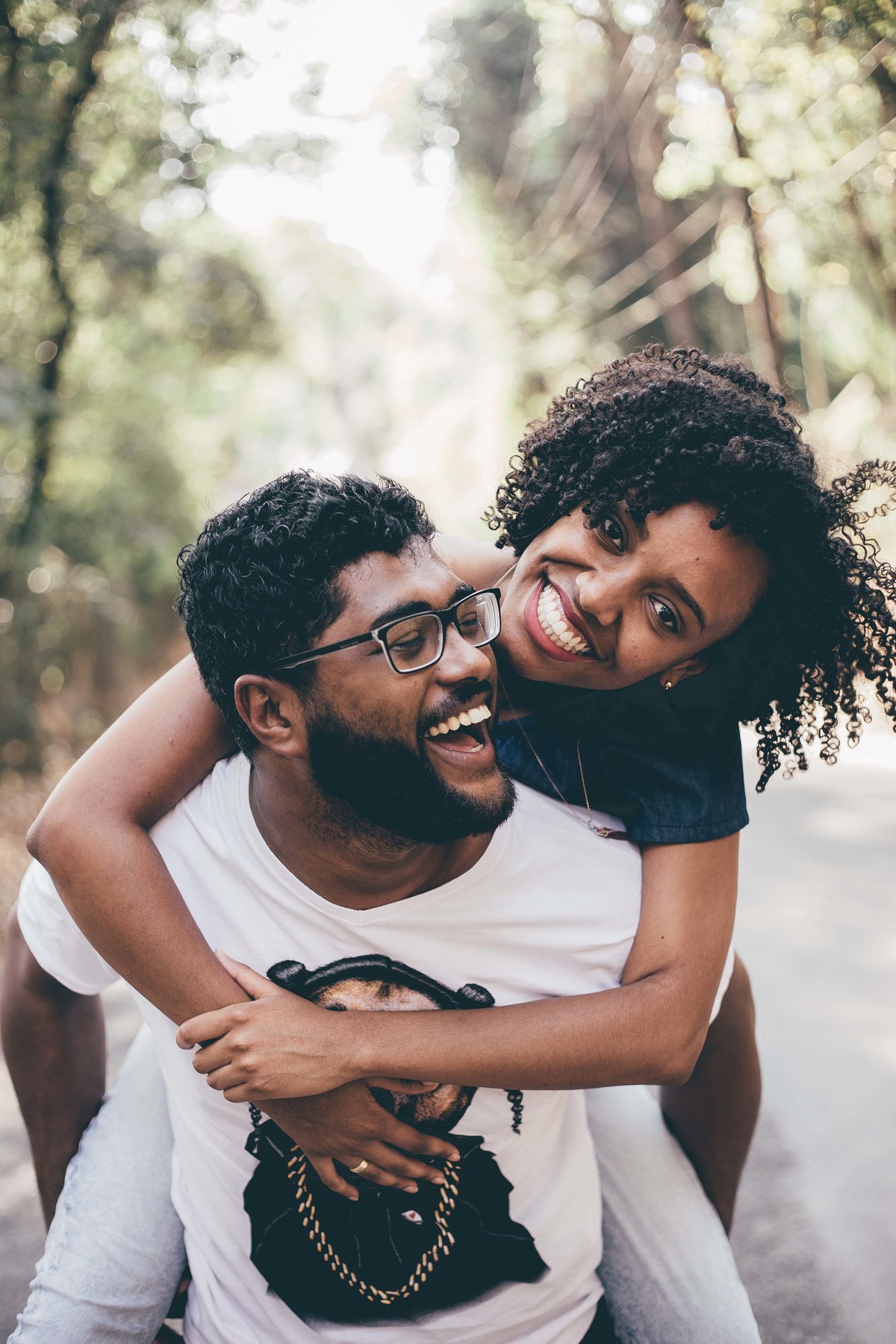 fotografia espontânea de casal em que a noiva esta de cavalinho e sorrindo um pro outro