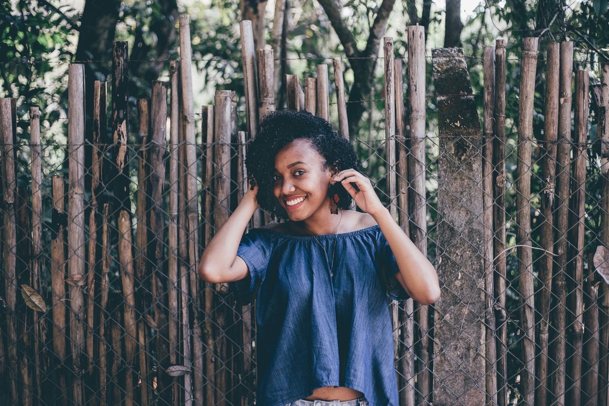 retrato feminino modelo com cabelo cacheado e sorrindo para a foto