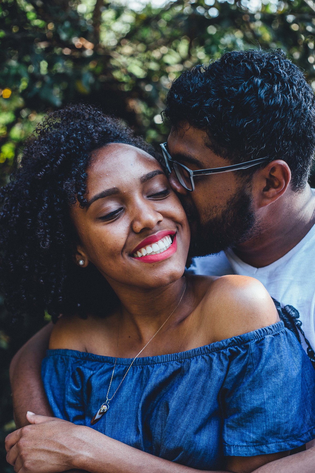 noivo beijando o rosto da noiva enquanto ela sorri