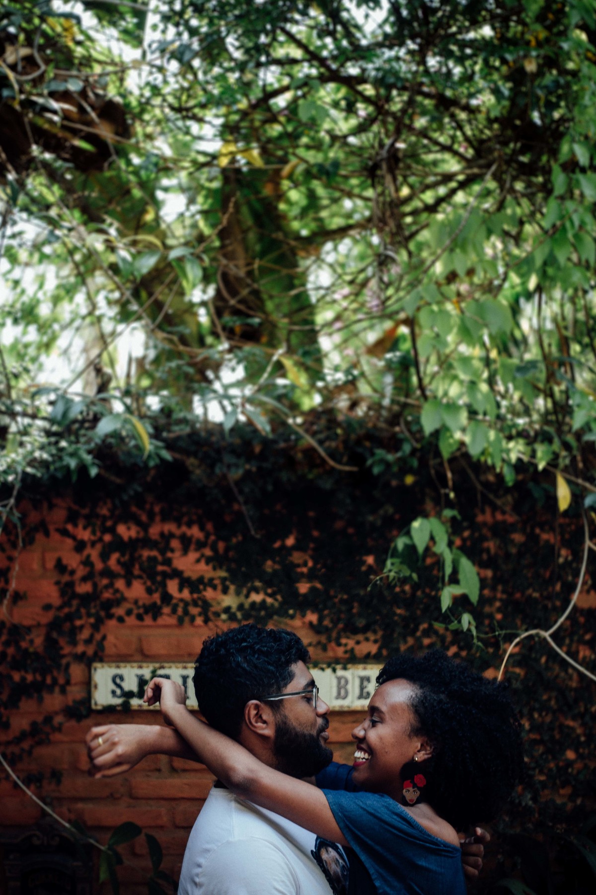 Noiva abraçando o noivo entrelaçando seu braço por trás do pescoço do noivo