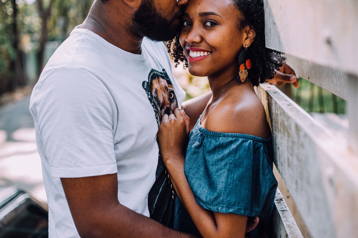 noiva olhando para a camera enquanto o noivo beija sua testa