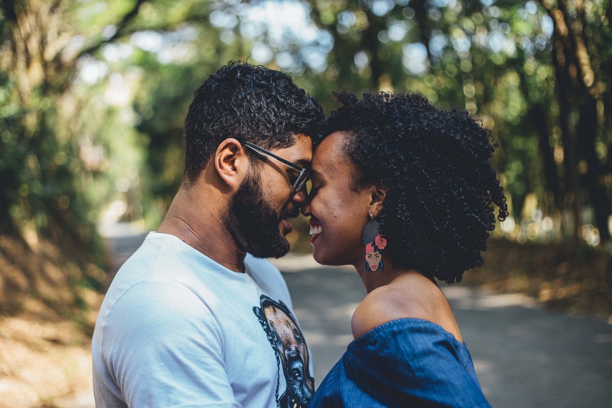 fotografia de casal encostando a cabeça uma na outra e sorrindo