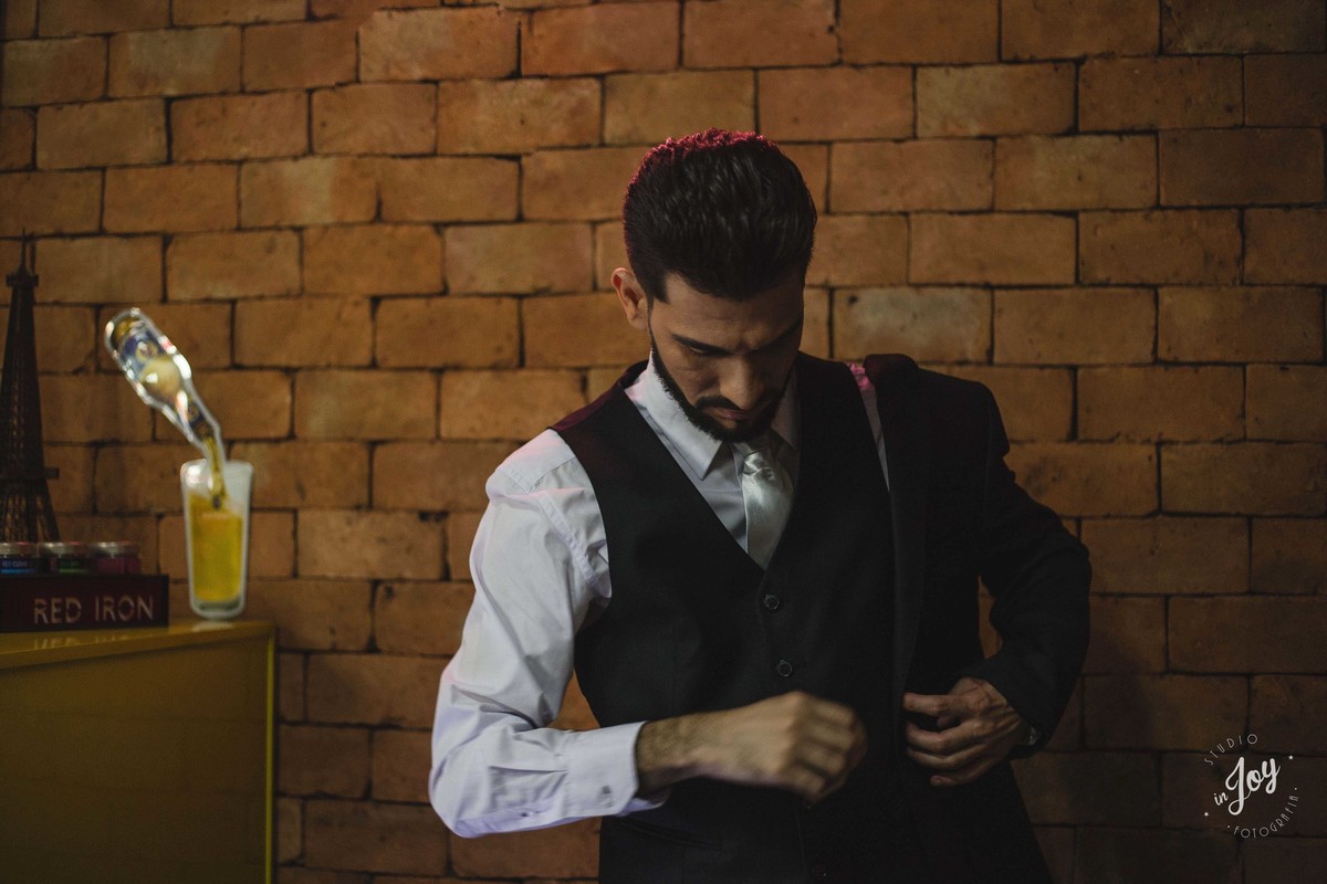 noivo vestindo o terno para o casamento