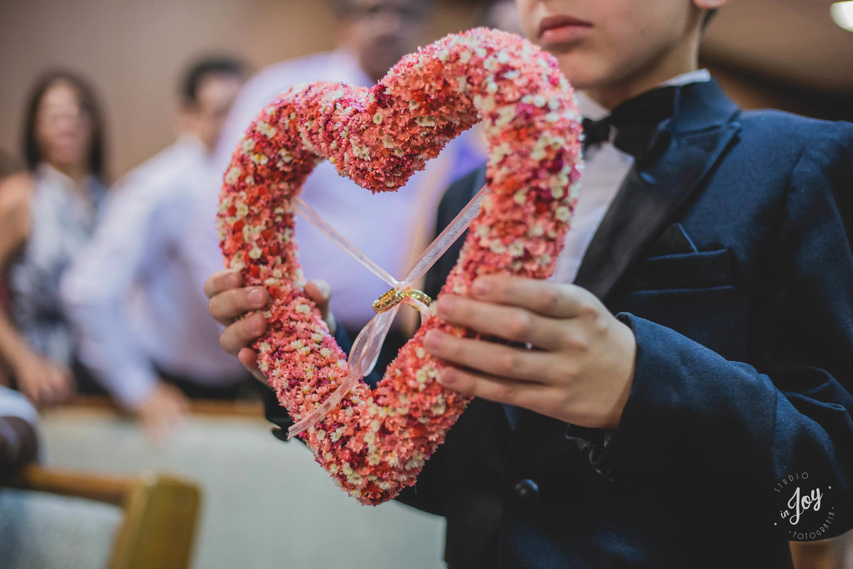 entrada das alianças dentro de um coração em um enfeite criativo para levar as alianças de casamento