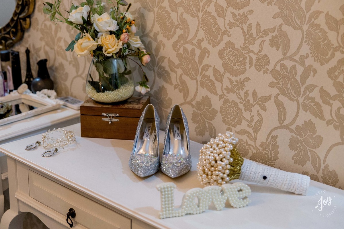 sapato de noiva junto com o boque de noiva de perolas
