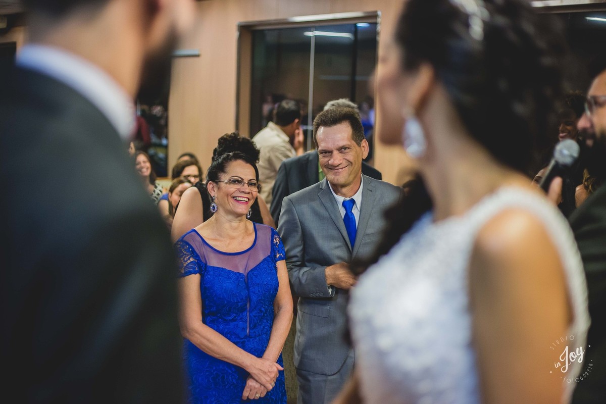 pais do noivo olhando os noivos e sorrindo para eles