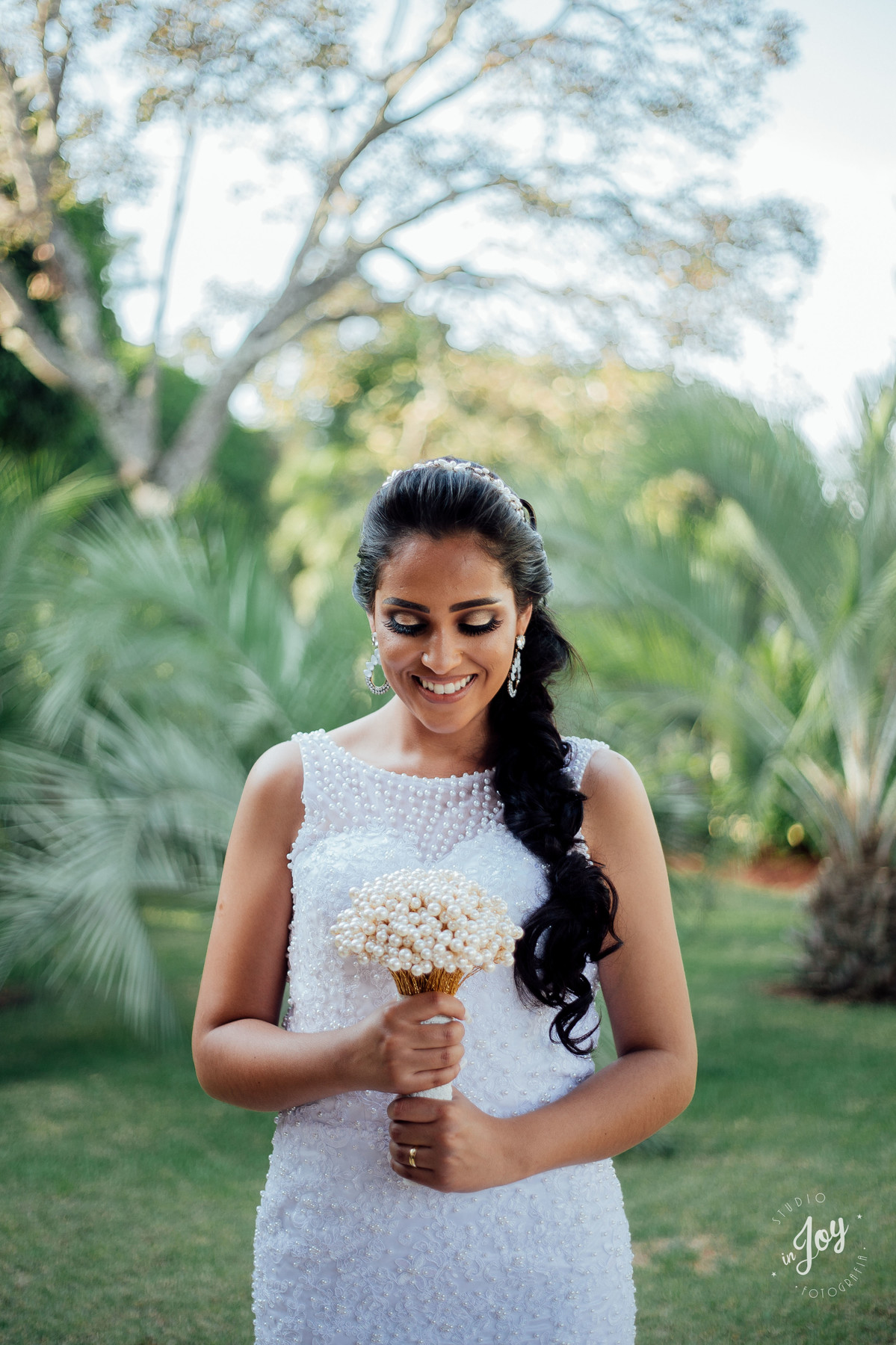 noiva segurando o boque e sorrindo com um lindo vestido de noiva sereia