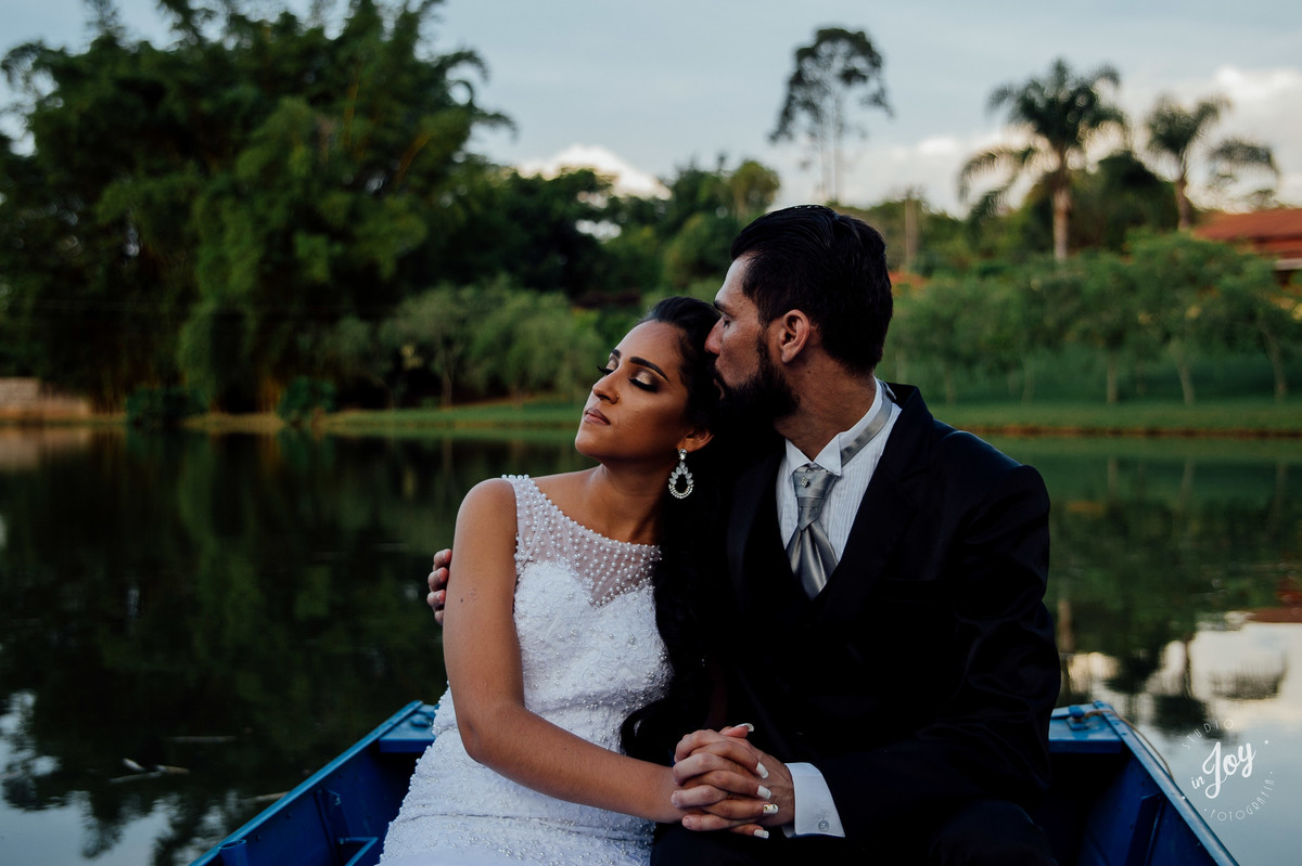 fotografia de pós casamento em que os noivos estão sentados em um barco no por do sol na fazenda shangrilá