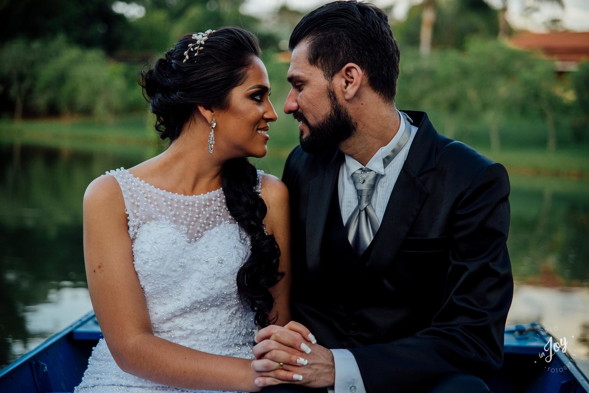 fotografia de pós casamento em que os noivos estão sentados em um barco no por do sol na fazenda shangrilá