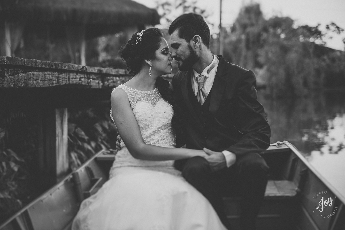 fotografia de pós casamento em que os noivos estão sentados em um barco no por do sol na fazenda shangrilá