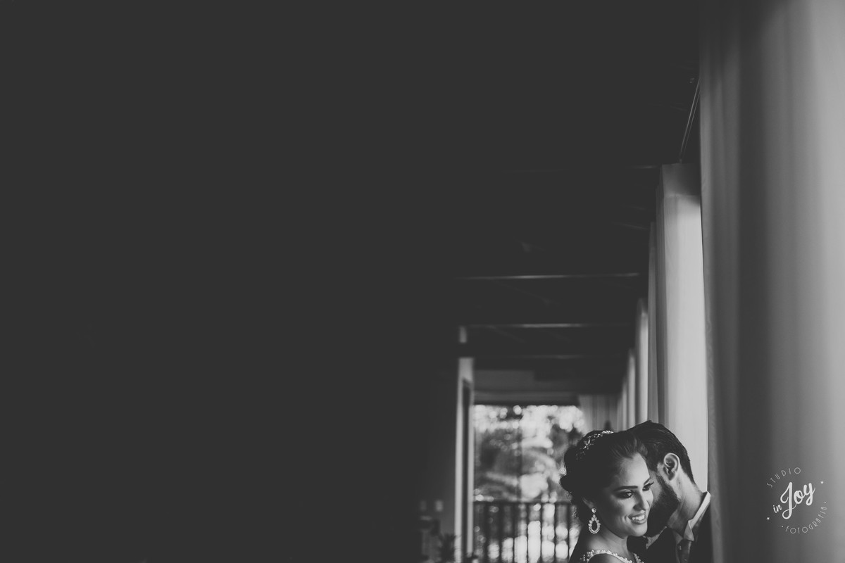 fotografia criativa de ensaio de pós casamento com um recorte bonito dos dois na janela se abraçando