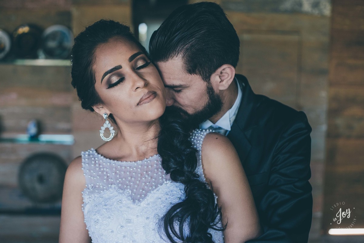 fotografia de casamento do casam que está se abraçando dentro de uma casa com detalhes de madeira