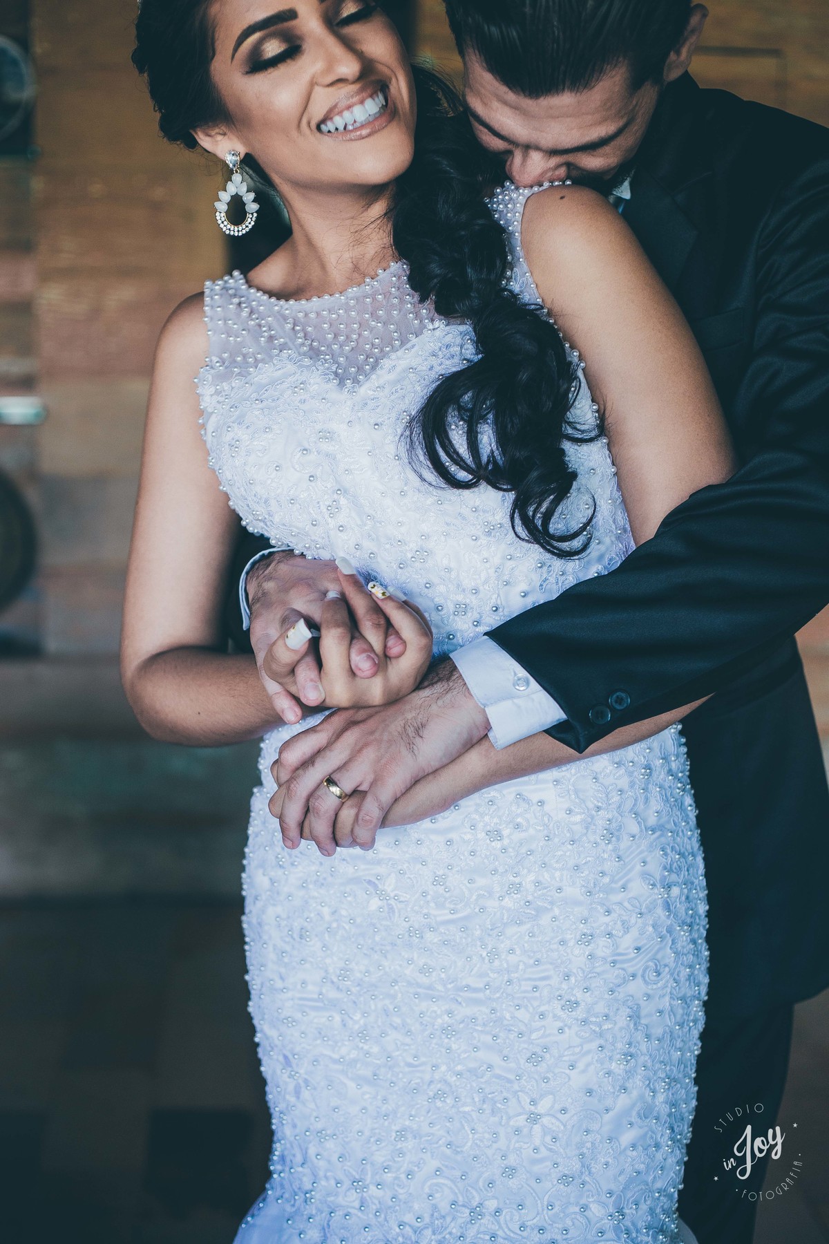 fotografia de casamento do casam que está se abraçando dentro de uma casa com detalhes de madeira