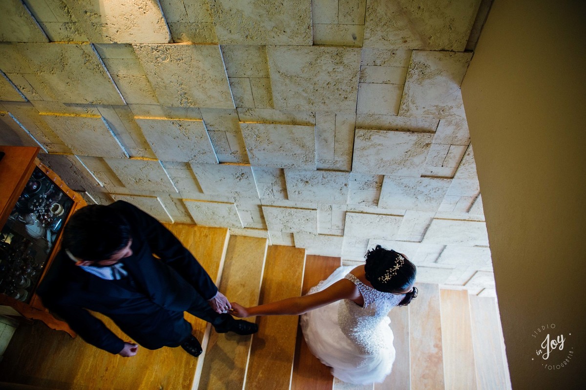 fotografia feita de cima dos noivos de mãos dadas e caminhando para a direção do amor