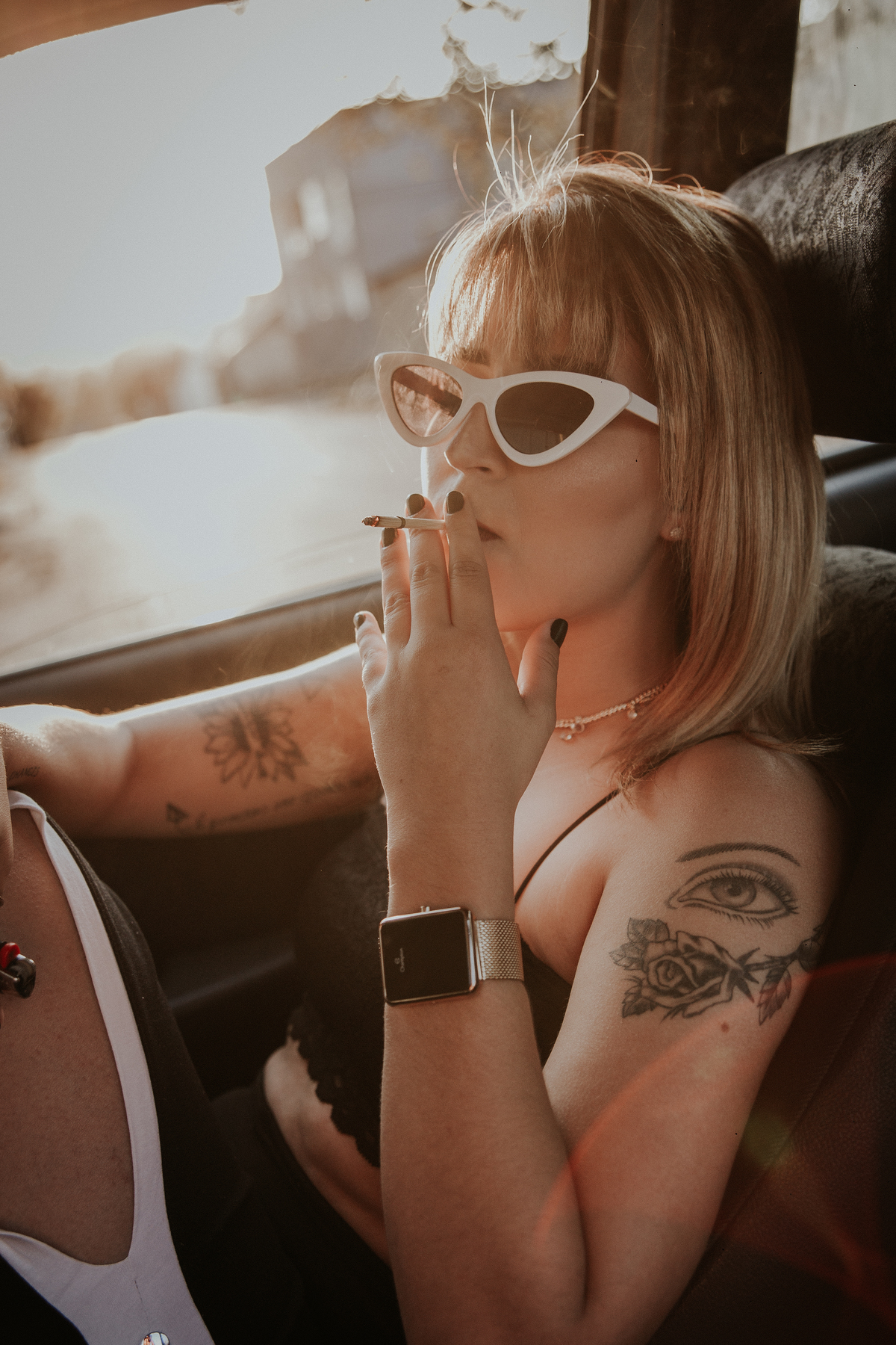 ensaio feminino em betim dentro do carro com uma inspiração de look com jaqueta corta vento, calça pantalona e oculos de sol retro