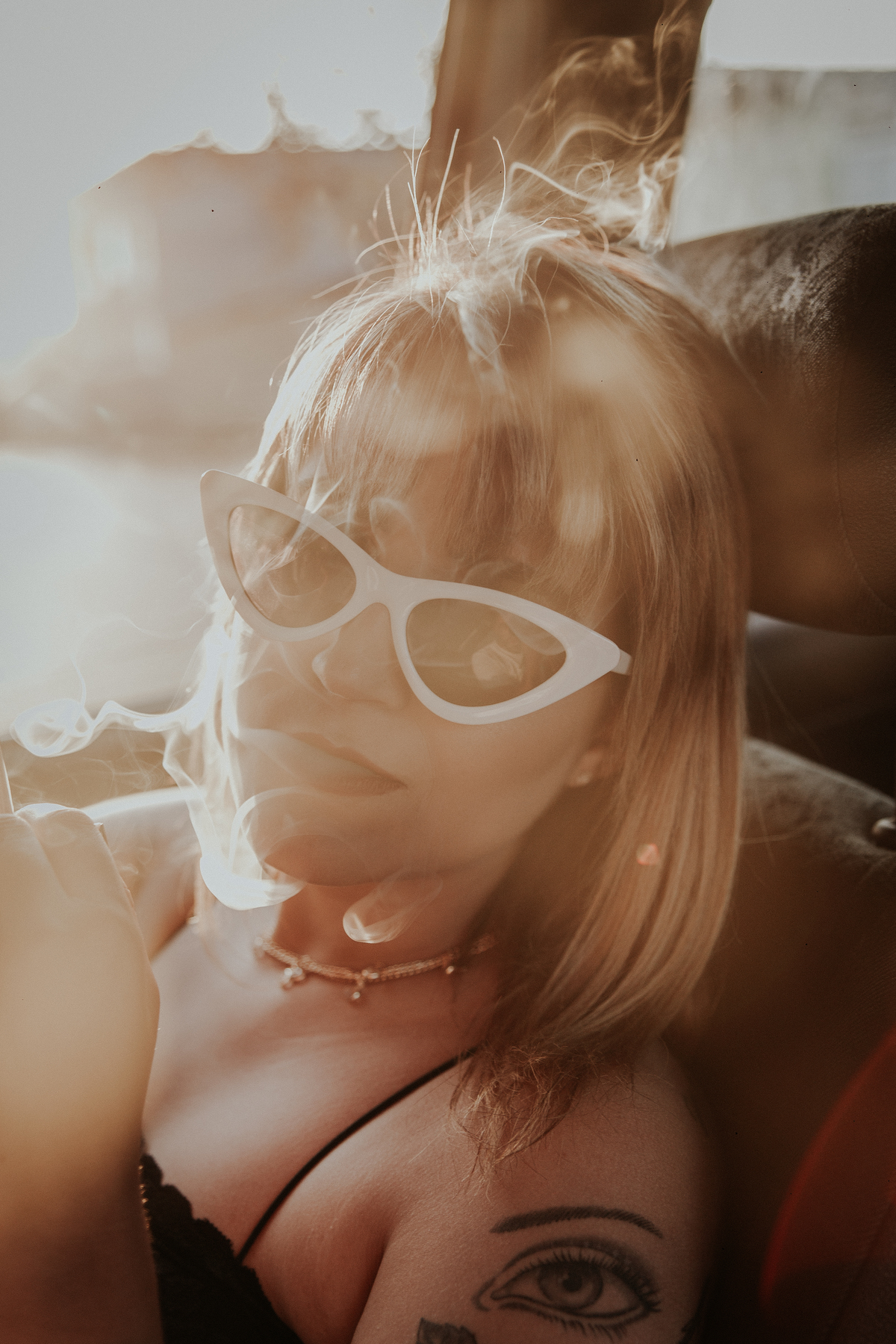 ensaio feminino em betim dentro do carro com uma inspiração de look com jaqueta corta vento, calça pantalona e oculos de sol retro