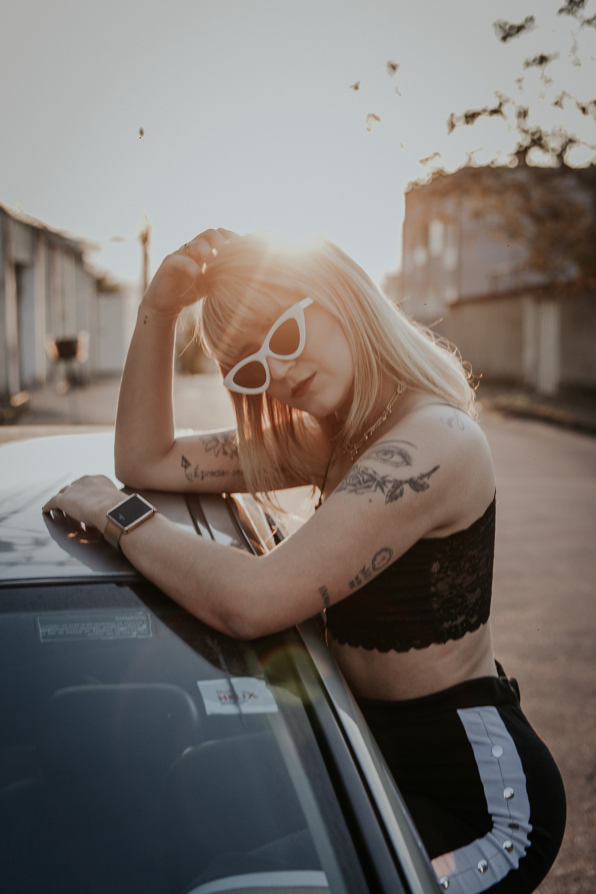 ensaio feminino em betim dentro do carro com uma inspiração de look com jaqueta corta vento, calça pantalona e oculos de sol retro