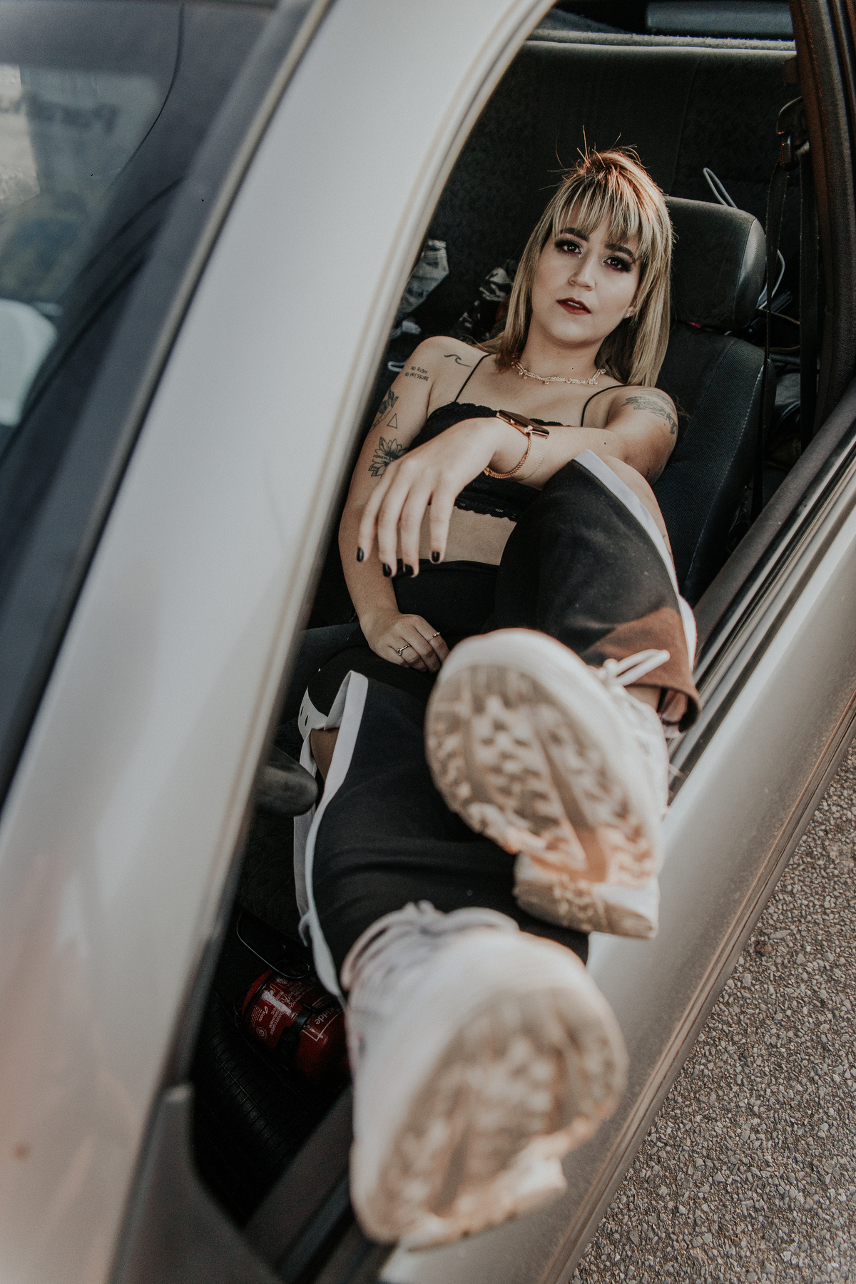 ensaio feminino em betim dentro do carro com uma inspiração de look com jaqueta corta vento e calça pantalona