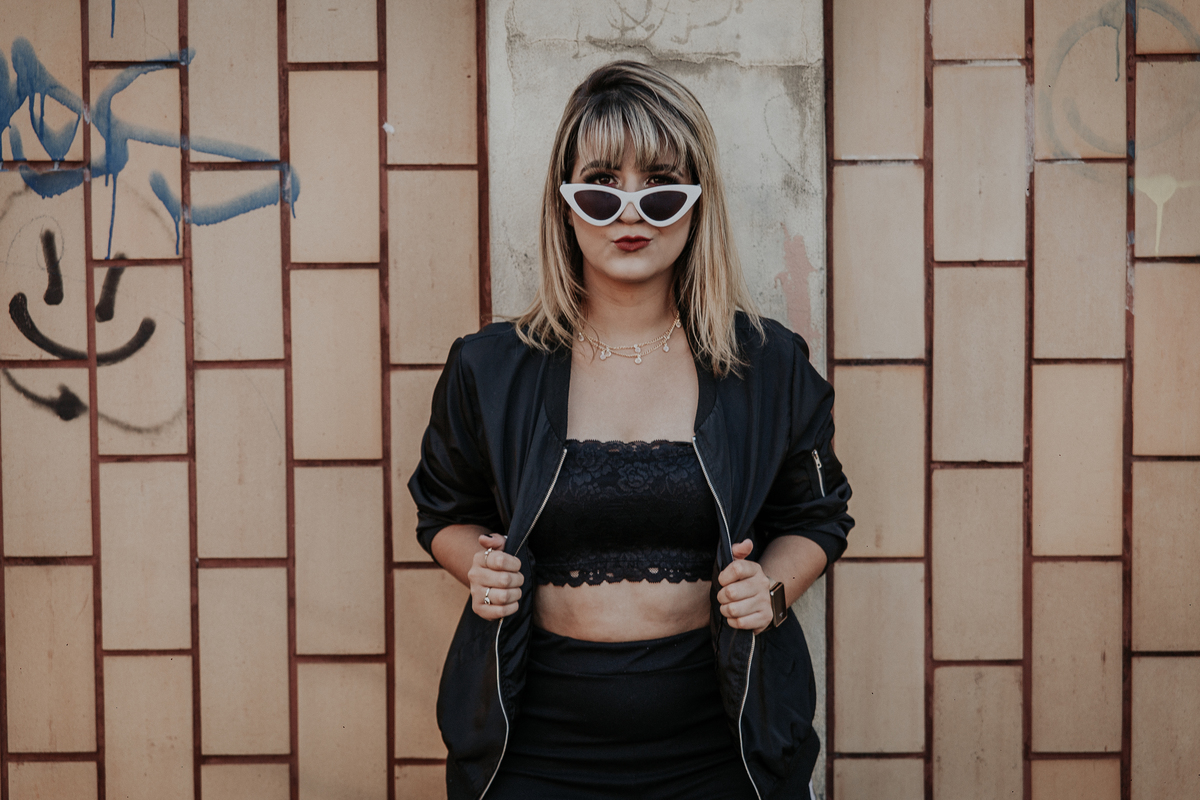 ensaio feminino em betim no estilo street portrait com uma inspiração de look com jaqueta corta vento, calça pantalona e oculos de sol retro