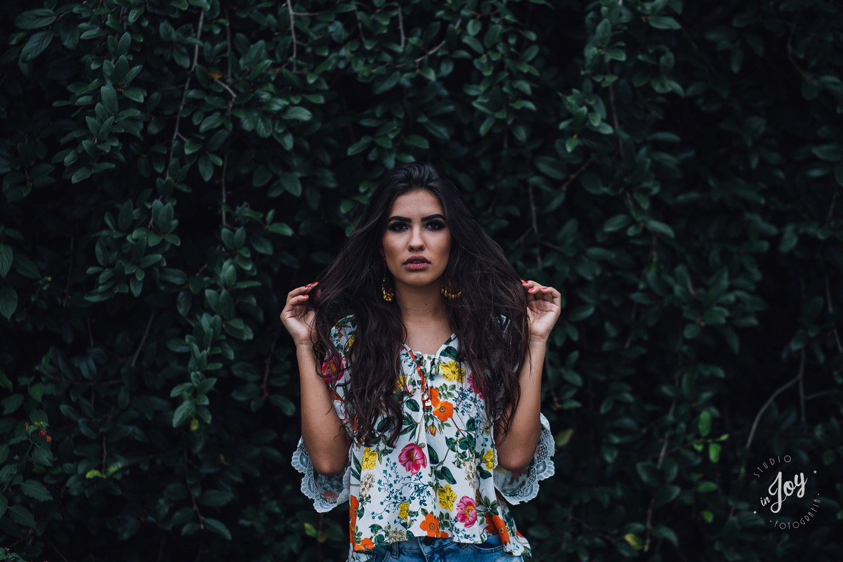 fotografia de moda em que a modelo esta segurando o cabelo com as duas mãos e olhando para o fotografo em um ensaio feminino
