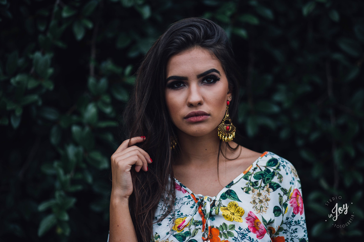 ensaio feminino em que a modelo esta olhando para a câmera e segurando o cabelo