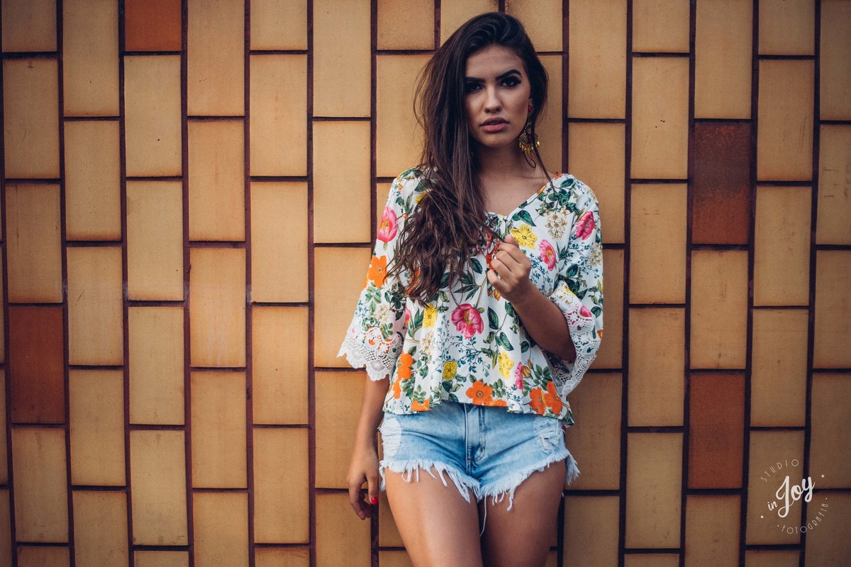 Ensaio fotografico feminino em que a modelo esta olhando para a câmera e fazendo pose para a foto