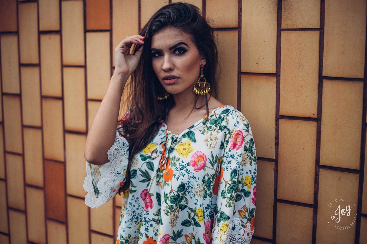 Ensaio fotografico feminino em que a modelo esta olhando para a câmera e fazendo pose para a foto