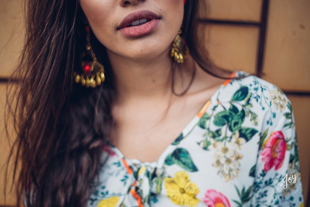 Fotografia de detalhes dos brincos e da boca da modelo fotográfica Alicia Bethania