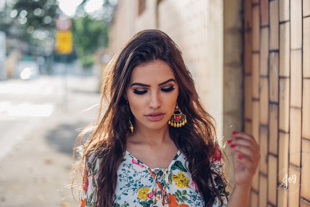 Fotografia de moda em que a modelo está mexendo no cabelo e caminhando pela rua