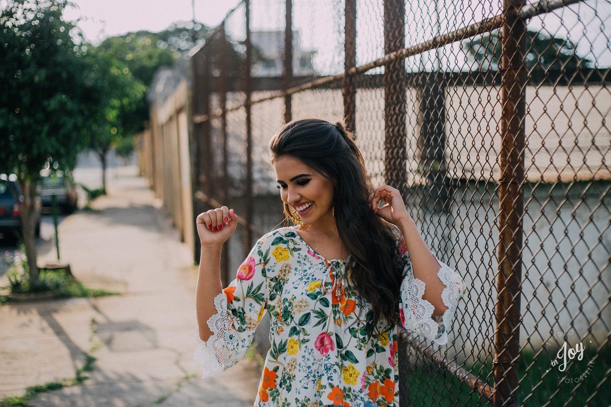 fotografia feminina espontânea em que  a modelo esta sorrindo e dançando em um ensaio fotografico urbano