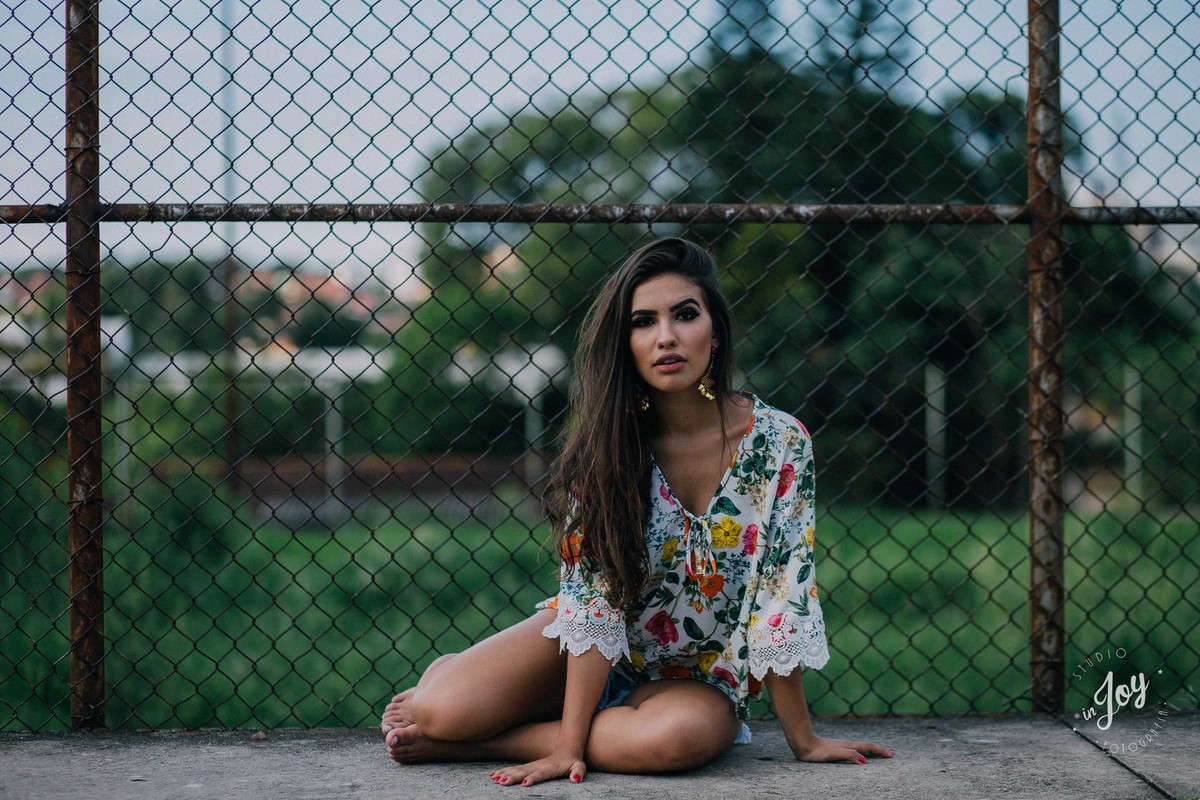 ensaio fotografico em Betim MG em que a modelo esta sentada e olhando para a camera