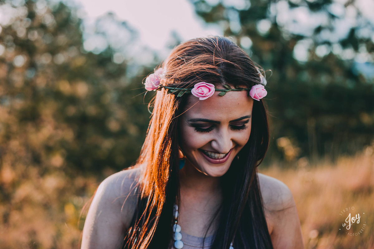 modelo sorrindo no por do sol com tiara de flores
