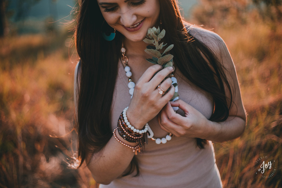 mulher sorrindo durante um ensaio fotografico no por sol realizado em macacos mg